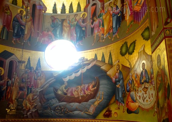 Remember after the Lord's crucifixion and resurrection when he gave Peter the injunction to feed his sheep? According to tradition, that occurred on the northwestern shore of the sea, not far from here, so this icon commemorates that event. Do you see the disciples pulling their catch into the boat? And see how Peter has jumped overboard and is swimming to the shore, where the Lord is waiting with the fire on which he will cook their breakfast?