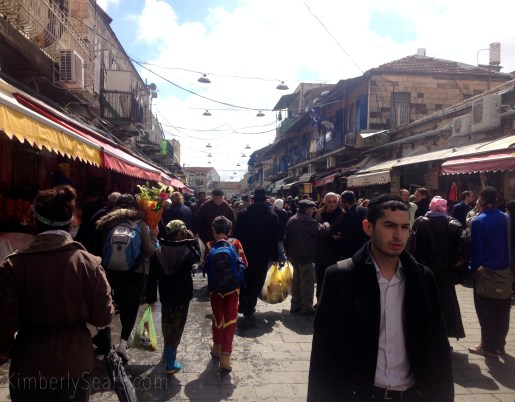 Two boys in costume, one dressed as Ironman and the other as an army soldier, walk down a street of Mahane Yehuda, the Jewish Market. Every year Purim costumes become a little more Americanized. 